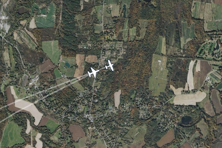flightaware planes 3x2 crop Aerial view of two small planes flying over a patchwork rural landscape with fields and forests leaving white contrails behind them