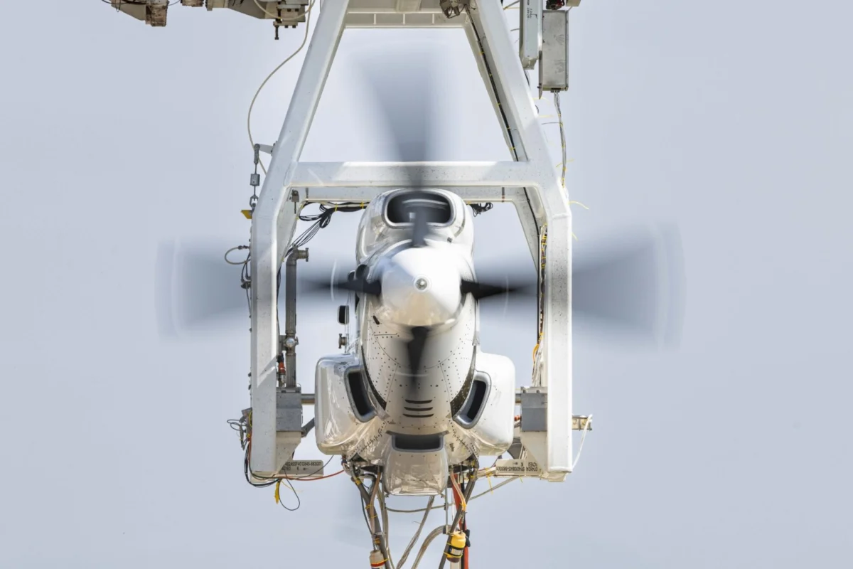 Front view of a propeller driven aircraft engine mounted in a metal test rig blades spinning blur