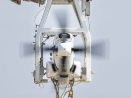Front view of a propeller driven aircraft engine mounted in a metal test rig blades spinning blur