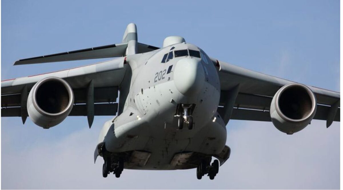 image Front down view of a large gray military cargo aircraft with landing gear extended two turbofan engines and wide wings against a blue sky