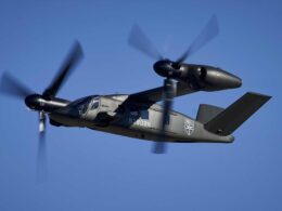 Bell V 280 Valor tiltrotor aircraft in flight rotors blurred against a clear blue sky