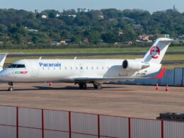 Paranair regional jet on the tarmac white fuselage with blue logo and red tail emblem registration ZP CRS orange cones nearby fence in foreground