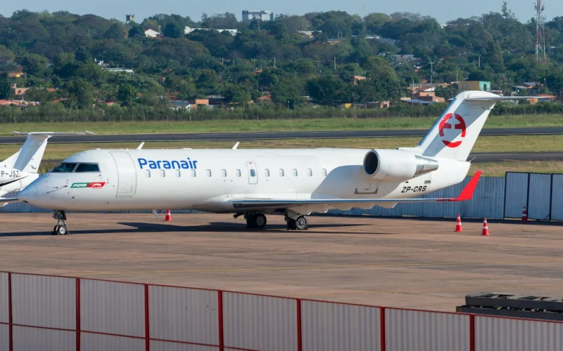Paranair regional jet on the tarmac white fuselage with blue logo and red tail emblem registration ZP CRS orange cones nearby fence in foreground