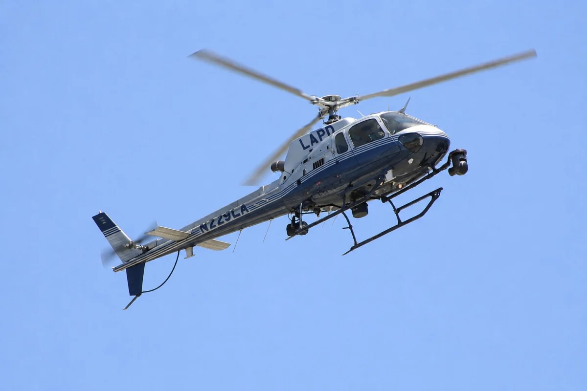 LAPD helicopter in flight against a clear blue skySide view showing the helicopter with LAPD on the fuselage and tail number visible