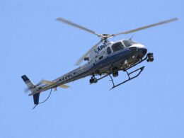 LAPD helicopter in flight against a clear blue skySide view showing the helicopter with LAPD on the fuselage and tail number visible