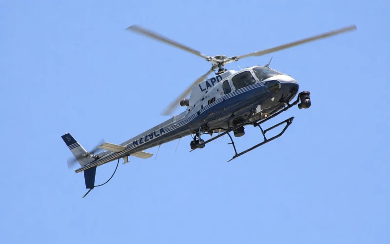 LAPD helicopter in flight against a clear blue skySide view showing the helicopter with LAPD on the fuselage and tail number visible