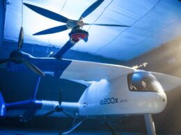 White e2000X PT01 tilt rotor aircraft inside a blue lit hangar rotors extended above the fuselage