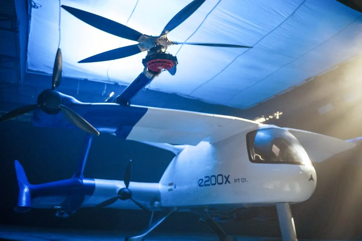 The ePlane Company e200X PT01 White e2000X PT01 tilt rotor aircraft inside a blue lit hangar rotors extended above the fuselage