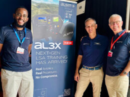 Three men stand beside a tall banner advertising al3x next gen LSA training at an aviation event
