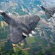 Two stealth bombers flying in formation over patchwork farmland seen from above