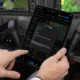 Pilot in cockpit holding a tablet showing flight plans and maps used to manage a flight