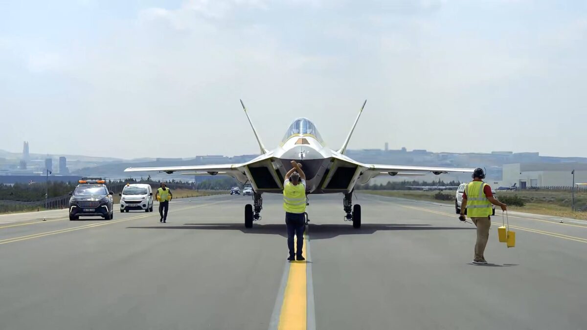The new P1 prototype of Türkiyes KAAN fighter conducts its first taxi test at TUSAŞ facilities in Ankara 1 Jet aircraft on a runway with crew in high visibility vests guiding it support vehicles nearby