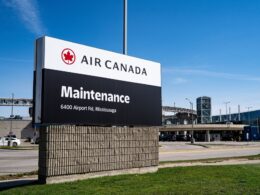 Air Canada Maintenance sign at an airport entrance with address 6400 Airport Rd Mississauga under a blue sky