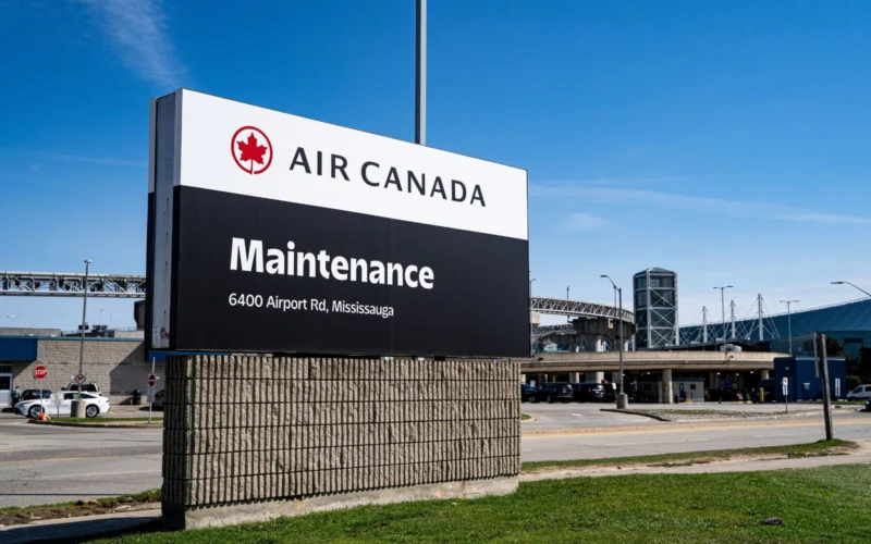 Air Canada Maintenance sign at an airport entrance with address 6400 Airport Rd Mississauga under a blue sky
