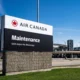 Air Canada Maintenance sign at an airport entrance with address 6400 Airport Rd Mississauga under a blue sky