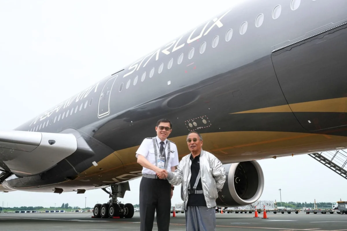 STARLUX Chairman Pilots Airsorayama Silver to Tokyo Two men shake hands in front of a large StarLux airplane on the tarmac one in a uniform