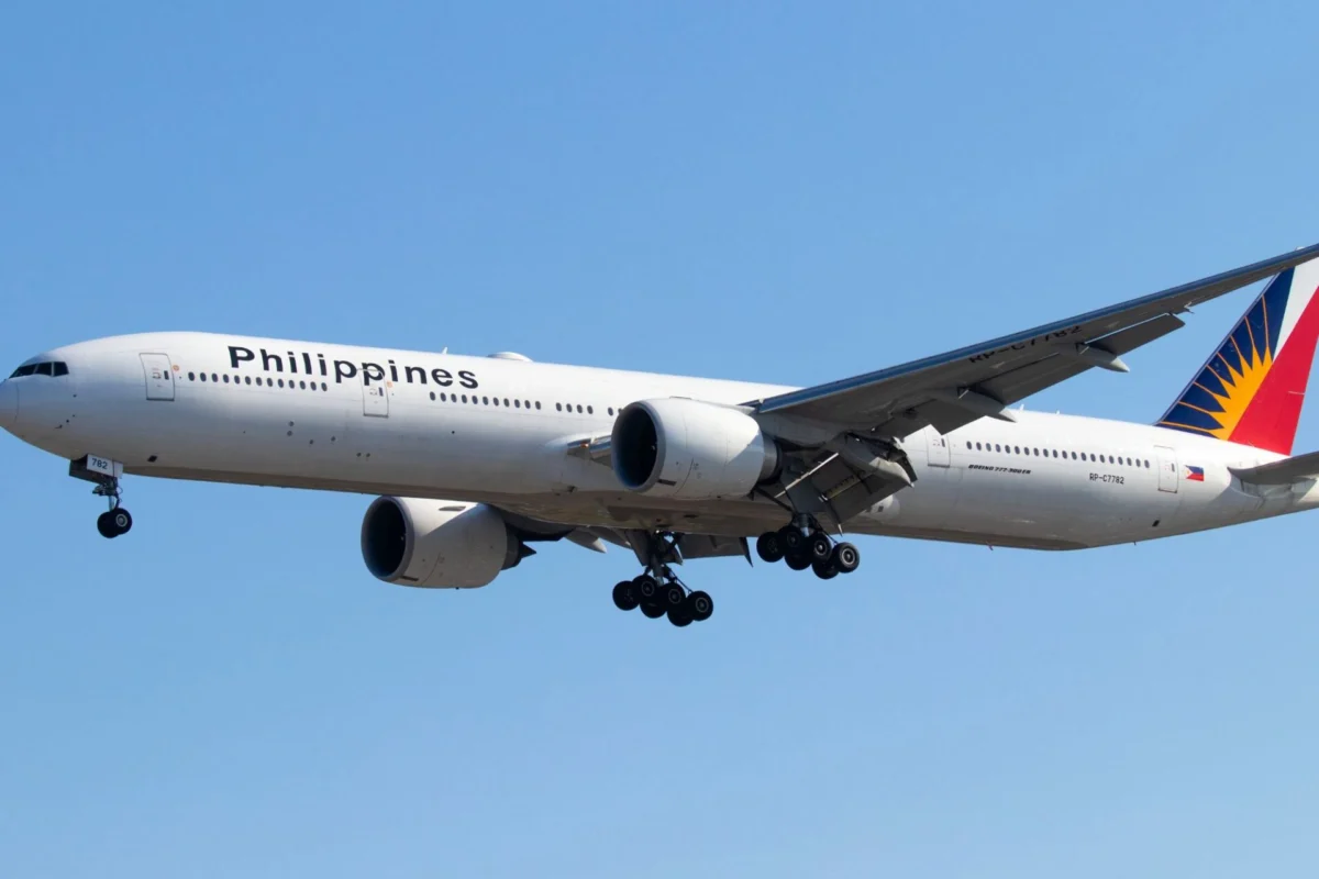 Philippine Airlines prices first international bond at 0M Wide view of a Philippines Airlines jet with landing gear extended flying low against a clear blue sky tail featuring a colorful design