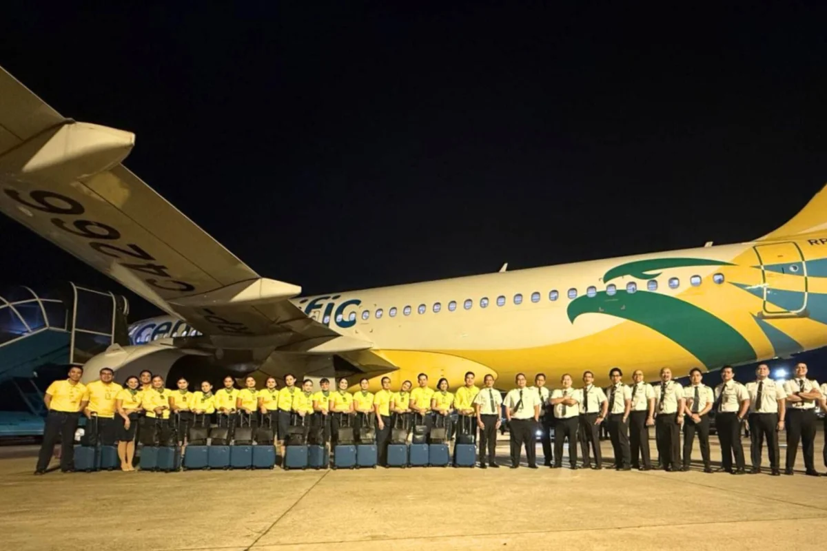 Cebu Pacific to wet lease A320neo to Vietnam Airlines Night time group photo of airline staff in yellow shirts standing in front of a colorful commercial airplane on the tarmac