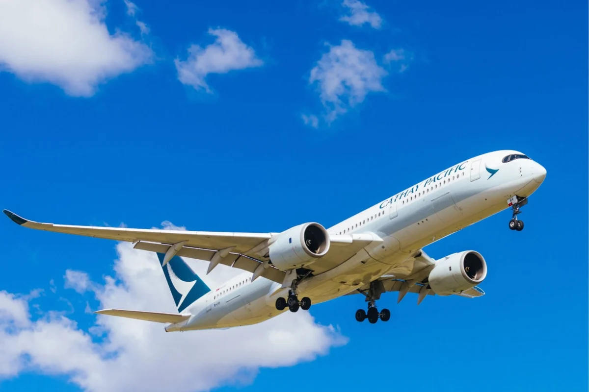 Cathay Pacific flight loses contact triggers NATO alert Cathay Pacific airliner in white livery ascending with its landing gear extended against a bright blue sky and scattered clouds