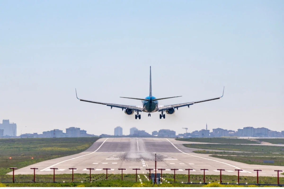 Asia Pacific airlines post 1 billion profit in 2025 Front view of a blue passenger jet landing on a runway with a city skyline in the distance