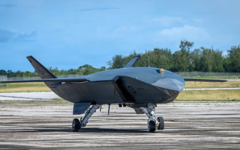 Stealth drone aircraft on a runway gray delta wing body with tail fins and landing gear visible