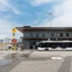 Airport tarmac with a yellow airplane at the gate a modern gray terminal building and a white bus in front