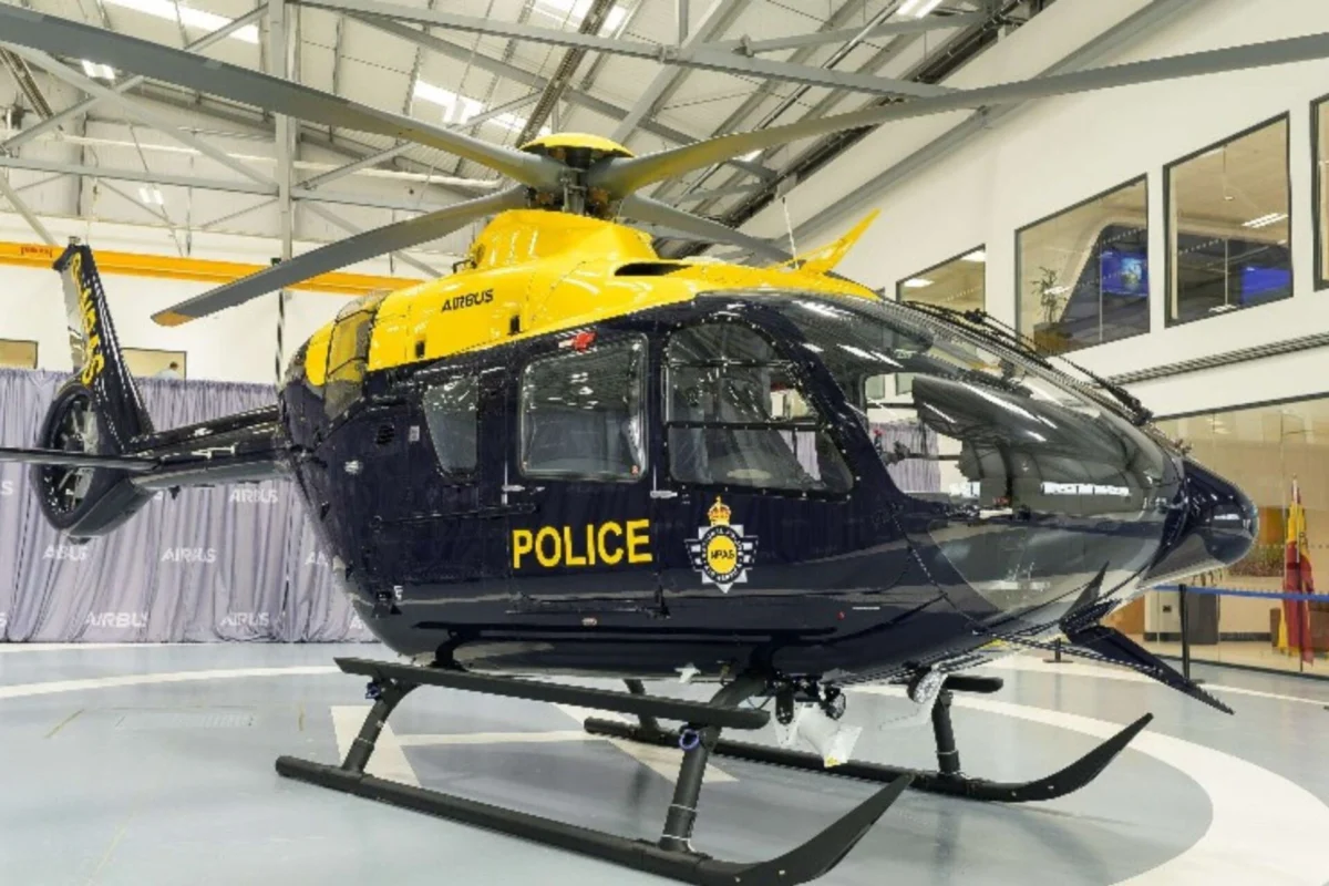 UKs National Police Air Service orders two more H135s Yellow and navy police helicopter on display inside a hangar with rotor blades extended
