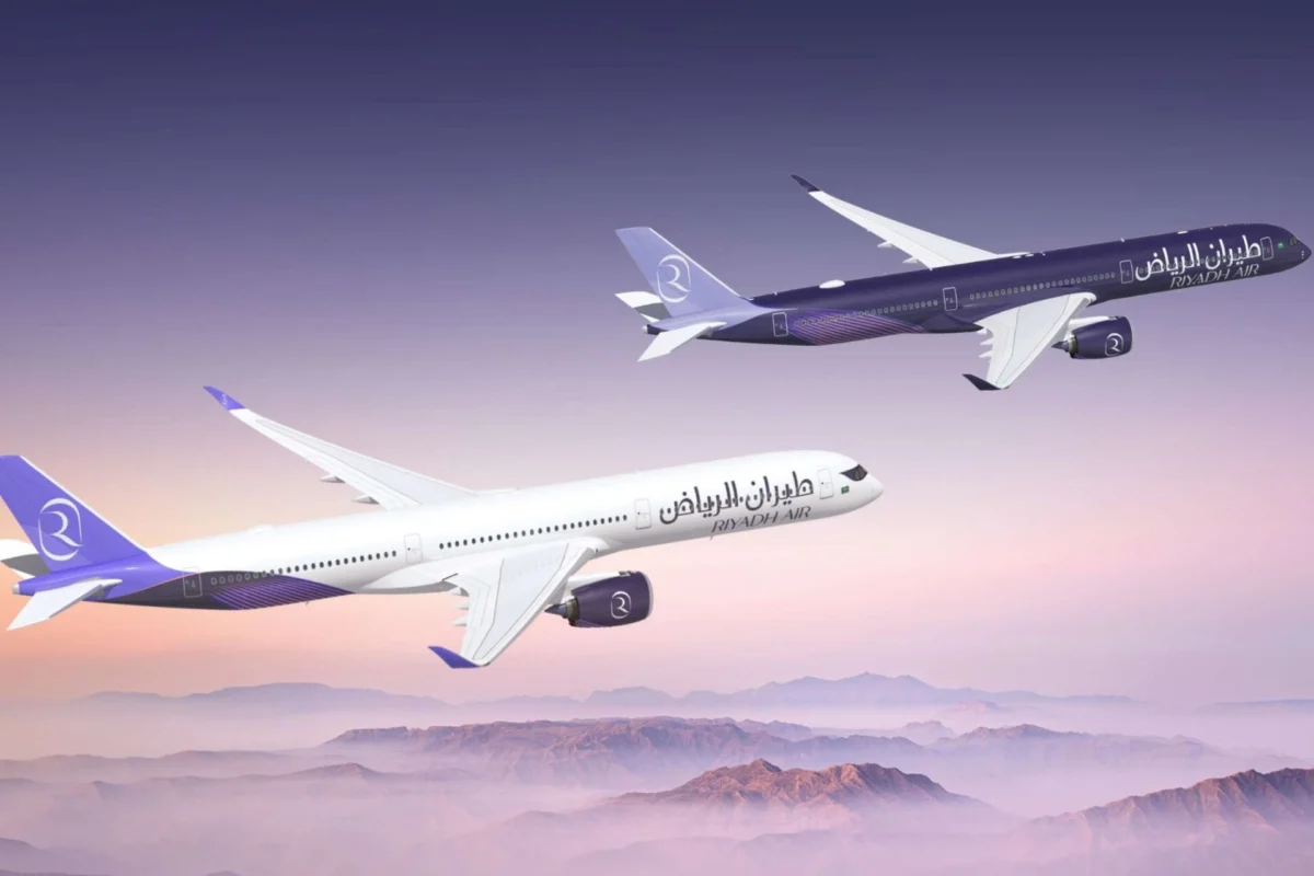 Riyadh Air firms up order for six more Airbus A350 1000s Two Riyadh Air airplanes in purple and white livery fly in formation over a purple pink sunset over a mountainous horizon tails branded with the airline logo