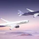 Two Riyadh Air airplanes in purple and white livery fly in formation over a purple pink sunset over a mountainous horizon tails branded with the airline logo