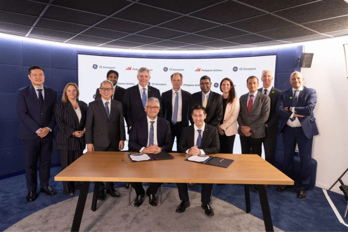 Philippine Airlines picks GE Aerospace for 787 10 fleet Group of executives in suits posing around a table as two leaders sign documents during a formal ceremony in front of a branded backdrop