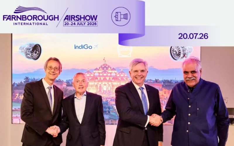 Four men in suits shake hands at Farnborough International Airshow banner reads 2024 July 2026