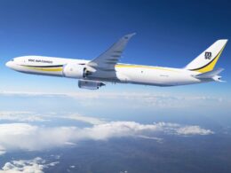 White MSC Air Cargo Boeing 777 freighter flying above clouds against a blue sky yellow and black tail logo visible