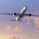 Commercial airliner photographed from below as it soars through a pastel sunset sky engines visible under the wings with a colorful tail