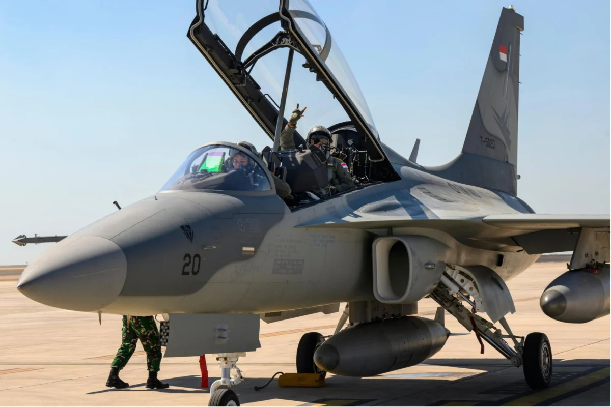 Indonesias T 50i Golden Eagle debuts at Pitch Black 26 Two pilots in an open cockpit of a fighter jet on a desert airstrip ground crew nearby preparing for taxiflight