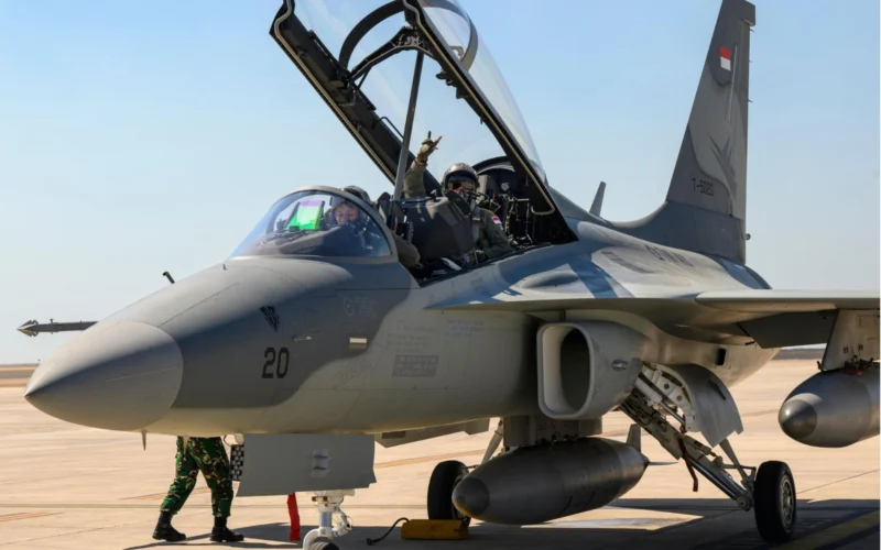 Two pilots in an open cockpit of a fighter jet on a desert airstrip ground crew nearby preparing for taxiflight
