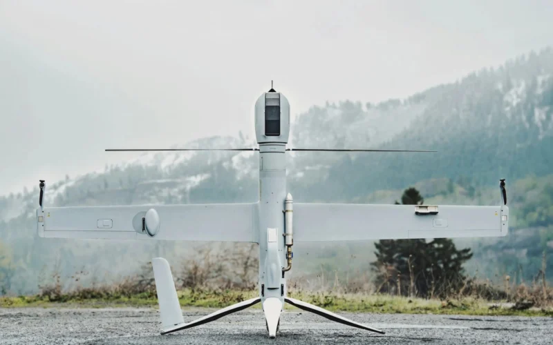 Unmanned aerial vehicle on a ground launch platform white body with long wings against a mountainous backdrop