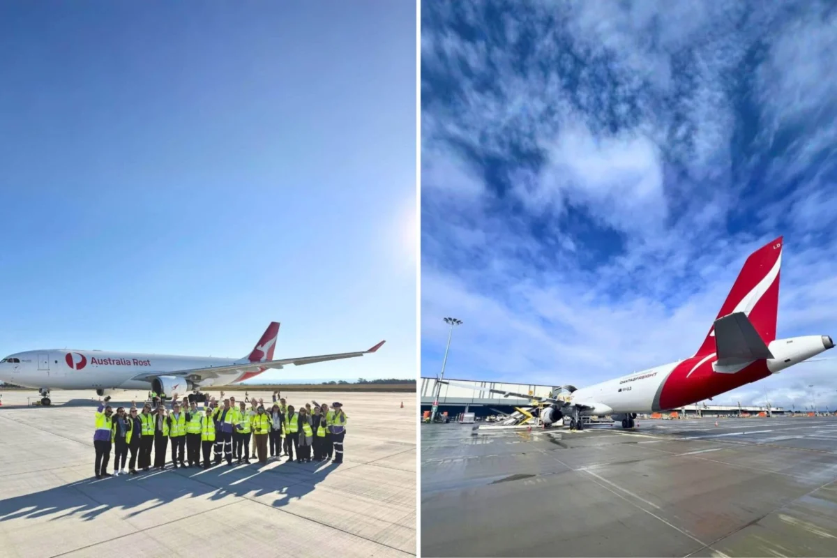 Group of airport ground crew in hi vis vests posing on the tarmac beside an Australia Post cargo jet