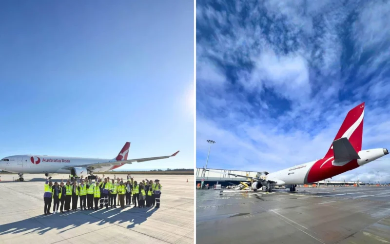 Group of airport ground crew in hi vis vests posing on the tarmac beside an Australia Post cargo jet
