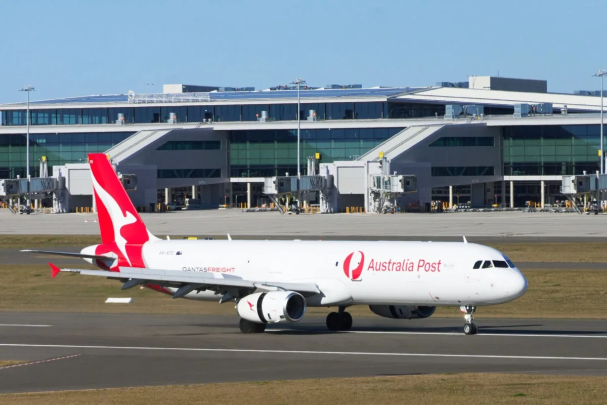 Qantas A321 first freighter to land at Western Sydney Australia Post aircraft with red tail at a modern airport terminal gate area
