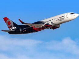Airplane in flight with white nose and black tail featuring Coulson Fireliner branding against a blue sky number 139 on the tail