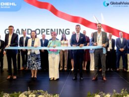 Group of professionals cutting a blue ribbon at a grand opening on a stage with DIEHL Aviation and GlobalVision logos in the background