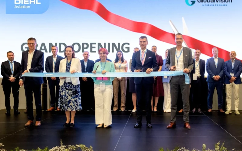 Group of professionals cutting a blue ribbon at a grand opening on a stage with DIEHL Aviation and GlobalVision logos in the background