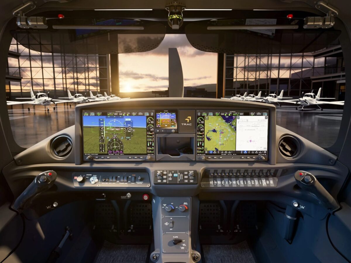 design Cockpit with multiple flight displays and control panels overlooking a hangar row of small airplanes at sunset outside the windows