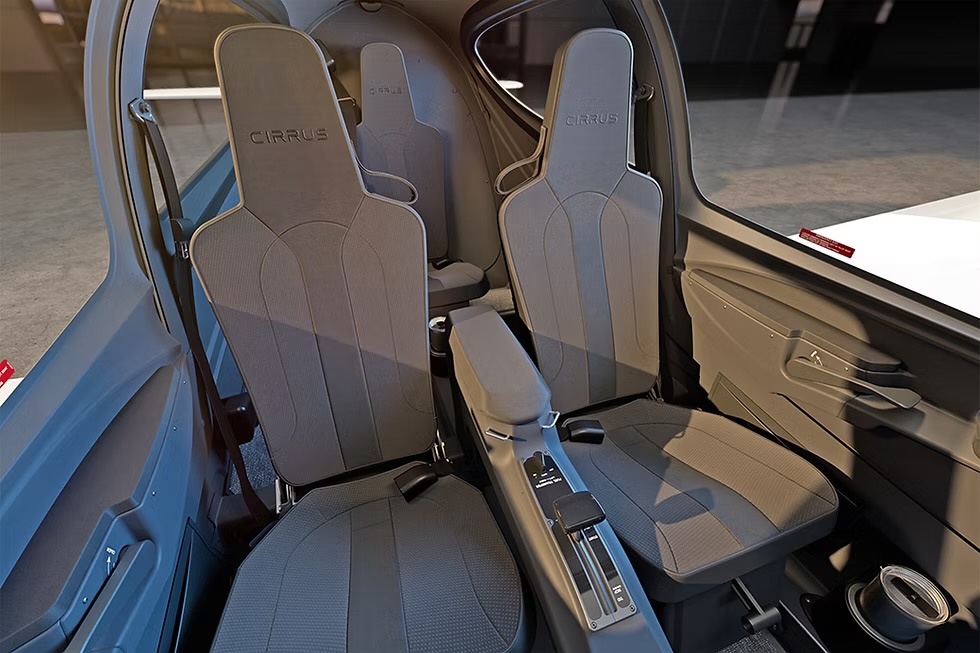 f57485 7eaabc54128d467384b7266b1b2ac420~mv2 Cockpit of a Cirrus airplane with two front seats and a central console between them gray fabric upholstery visible