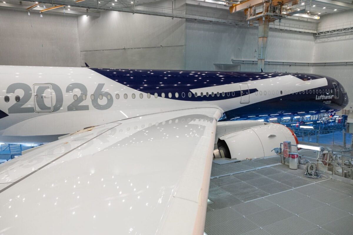 image Lufthansa airliner inside a maintenance hangar with wing and engine visible and the number 2026 on the fuselage