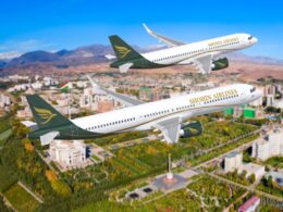 Two Shohin Airlines planes fly in formation over a city with green parks and mountains in the background blue sky overhead