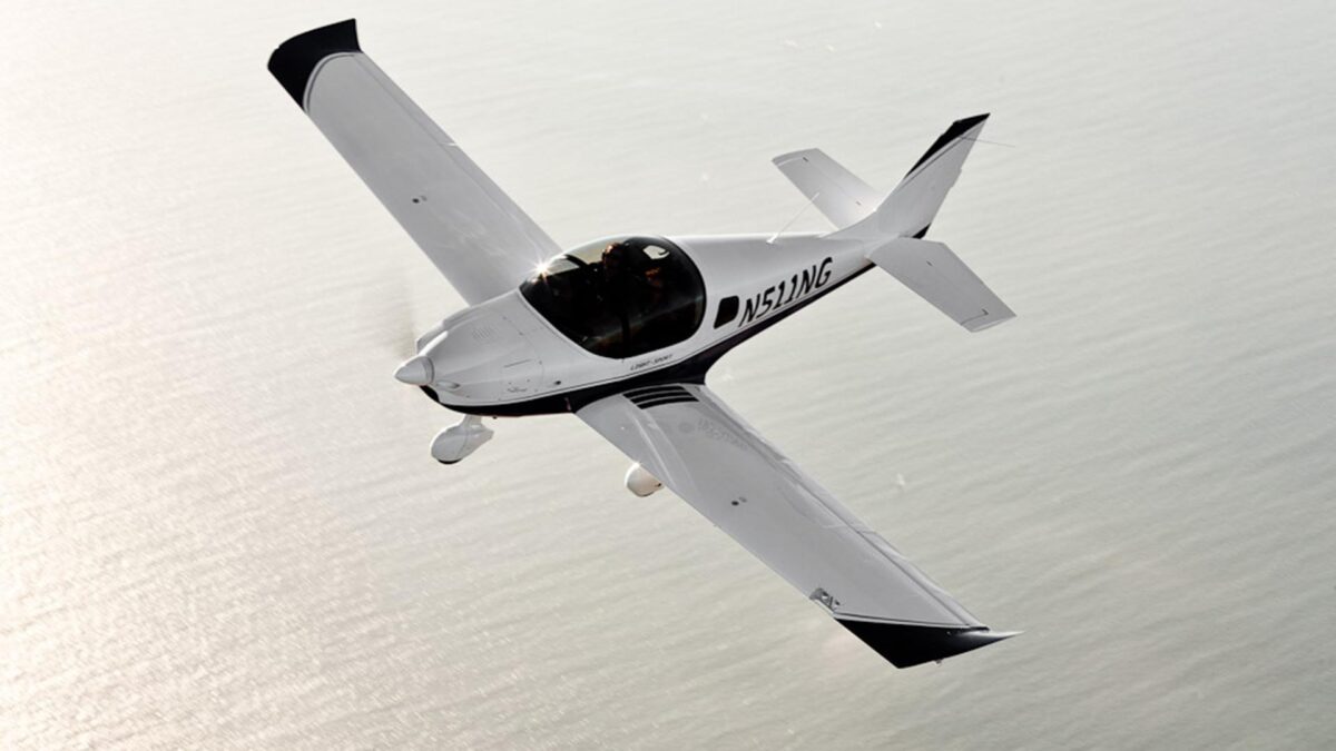 sling White single engine aircraft with a bubble canopy flying over the ocean registration N511WG visible along the fuselage