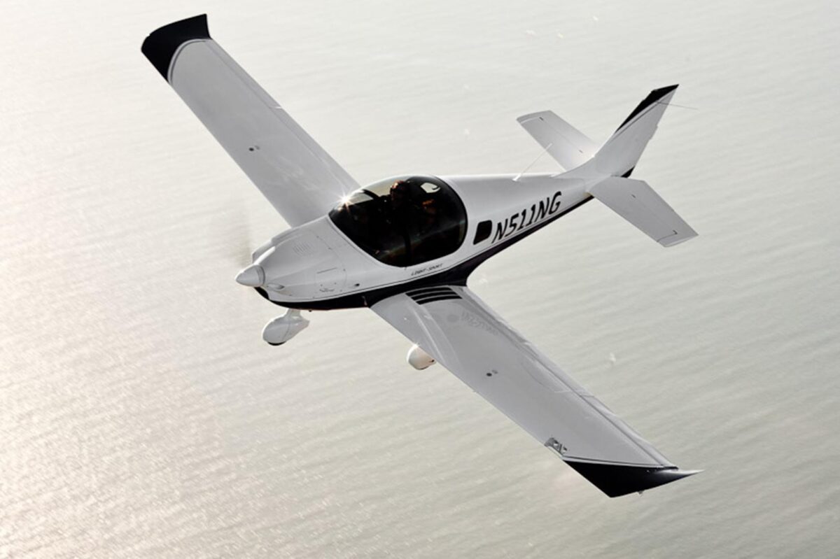 sling White single engine aircraft with a bubble canopy flying over the ocean registration N511WG visible along the fuselage