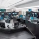 Control room filled with workstations and multiple screens displaying maps and data on their monitors