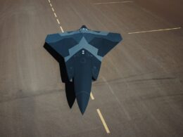 Top down view of a dark blue stealth jet on a runway seen from above